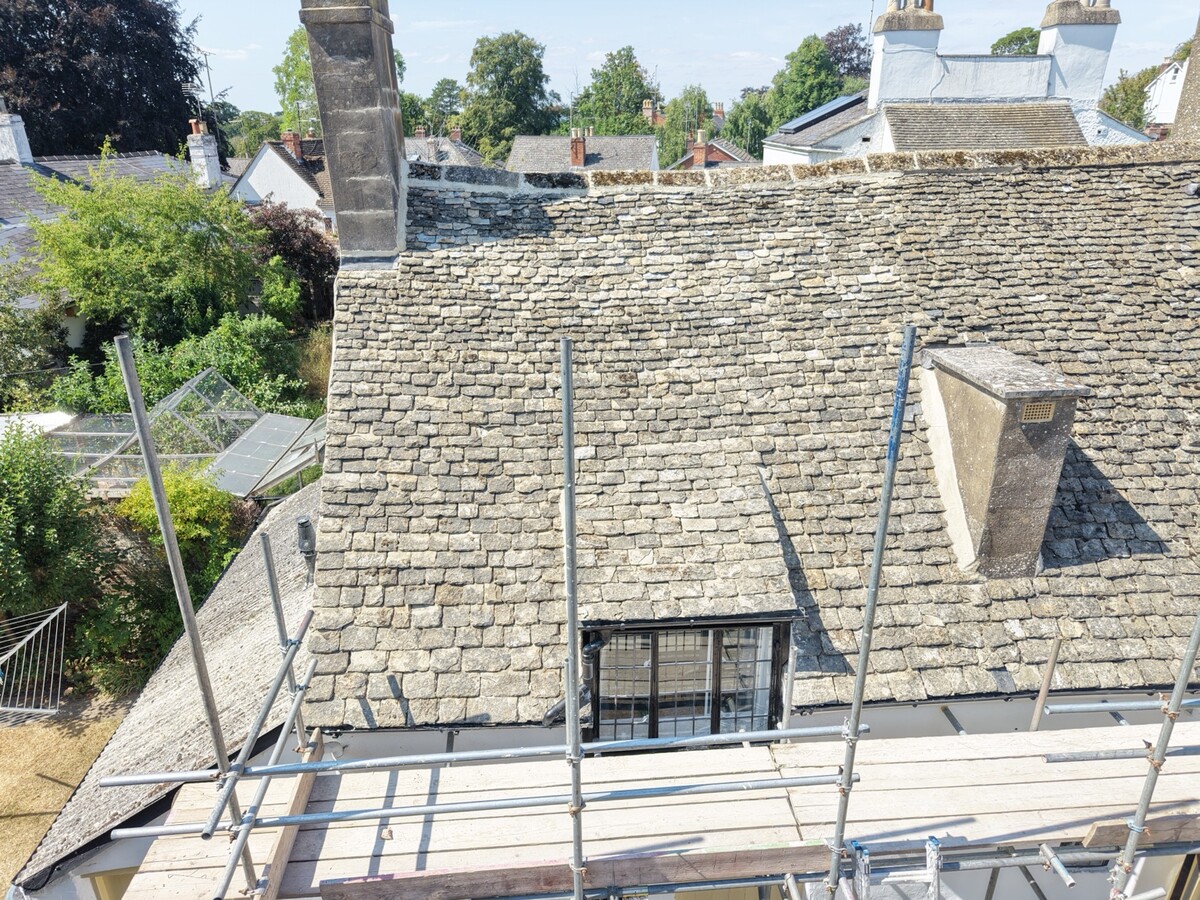 Stone roof with dormer and chimney stacks, viewed from the scaffolding at Cudnall Street, Charlton Kings