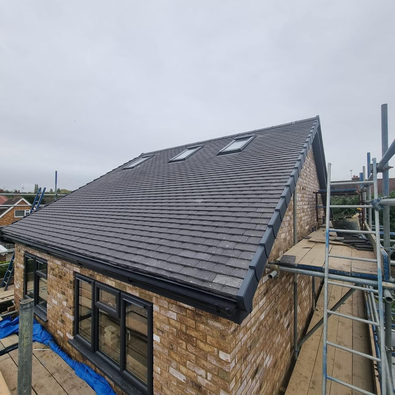 Dark pitched roof with rooflights above a stone house