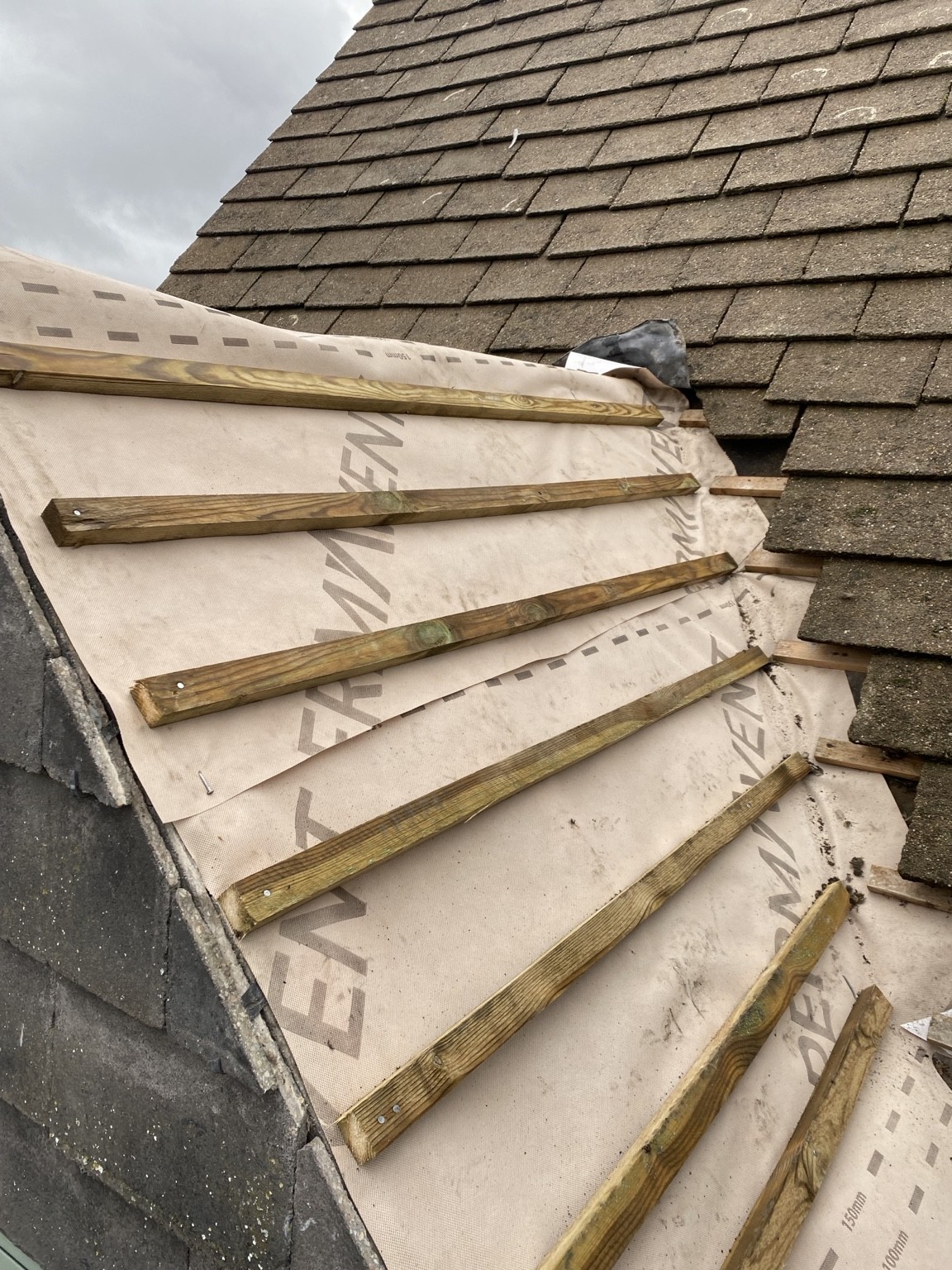Roof membrane and battens at a junction with an existing roof