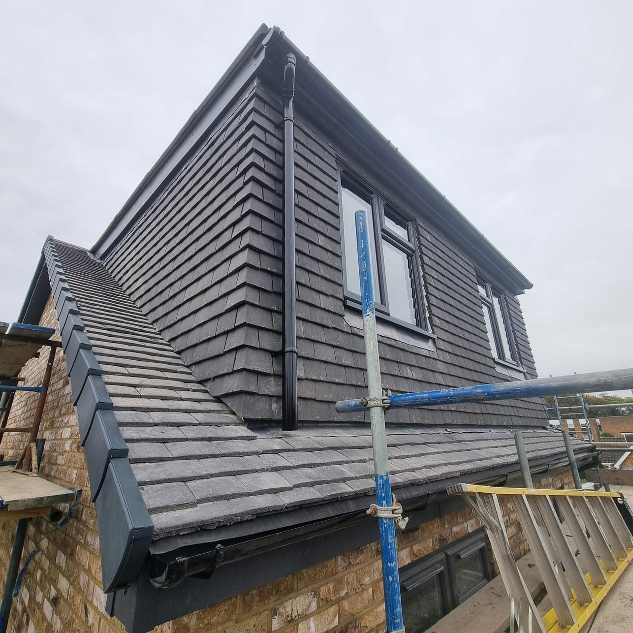 Slate-clad dormer with windows and scaffolding
