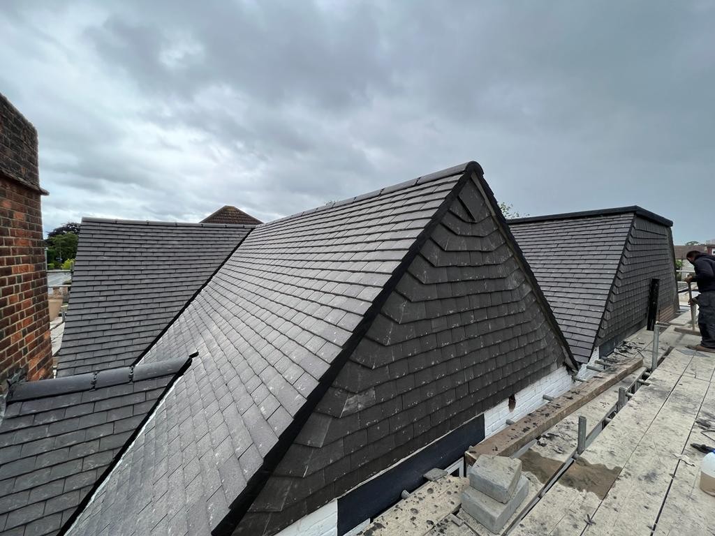 Two slate-clad dormers on a pitched roof